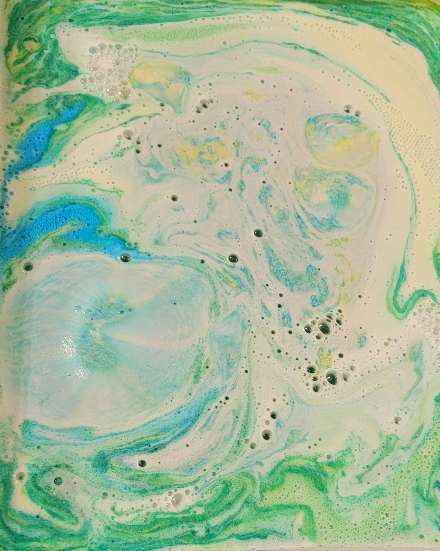 Water results of bath bomb. Blue, yellow and green. 
