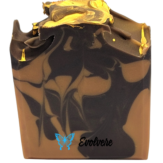 A brown and tan swirled bar of soap with a gold textured top.