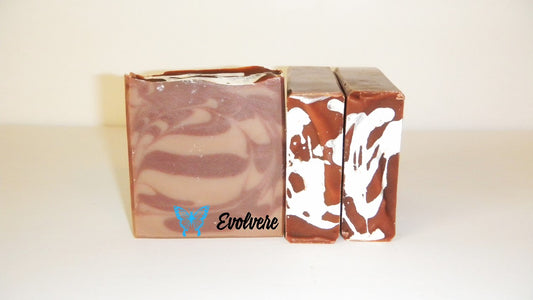 A brown and tan swirled soap with white drizzled on the top.