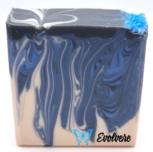 A black, white and two shades of blue swirled soap topped with blue sea salt.