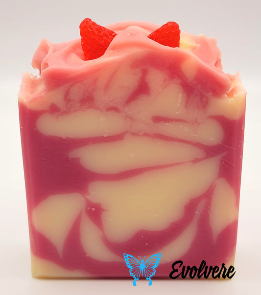 Pink and white soap bar with two soap strawberries on top
