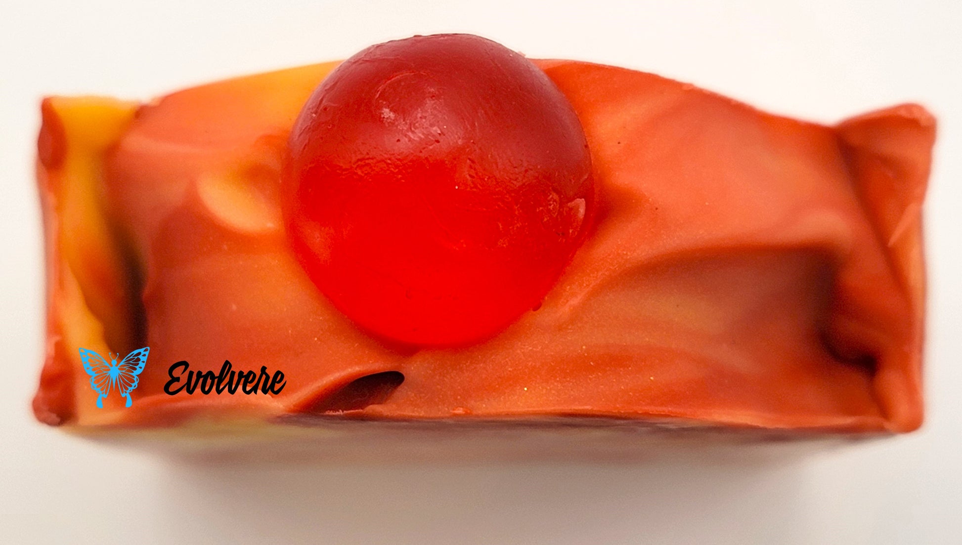 Soap bar top red, yellow and orange in color with a red soap ball in center