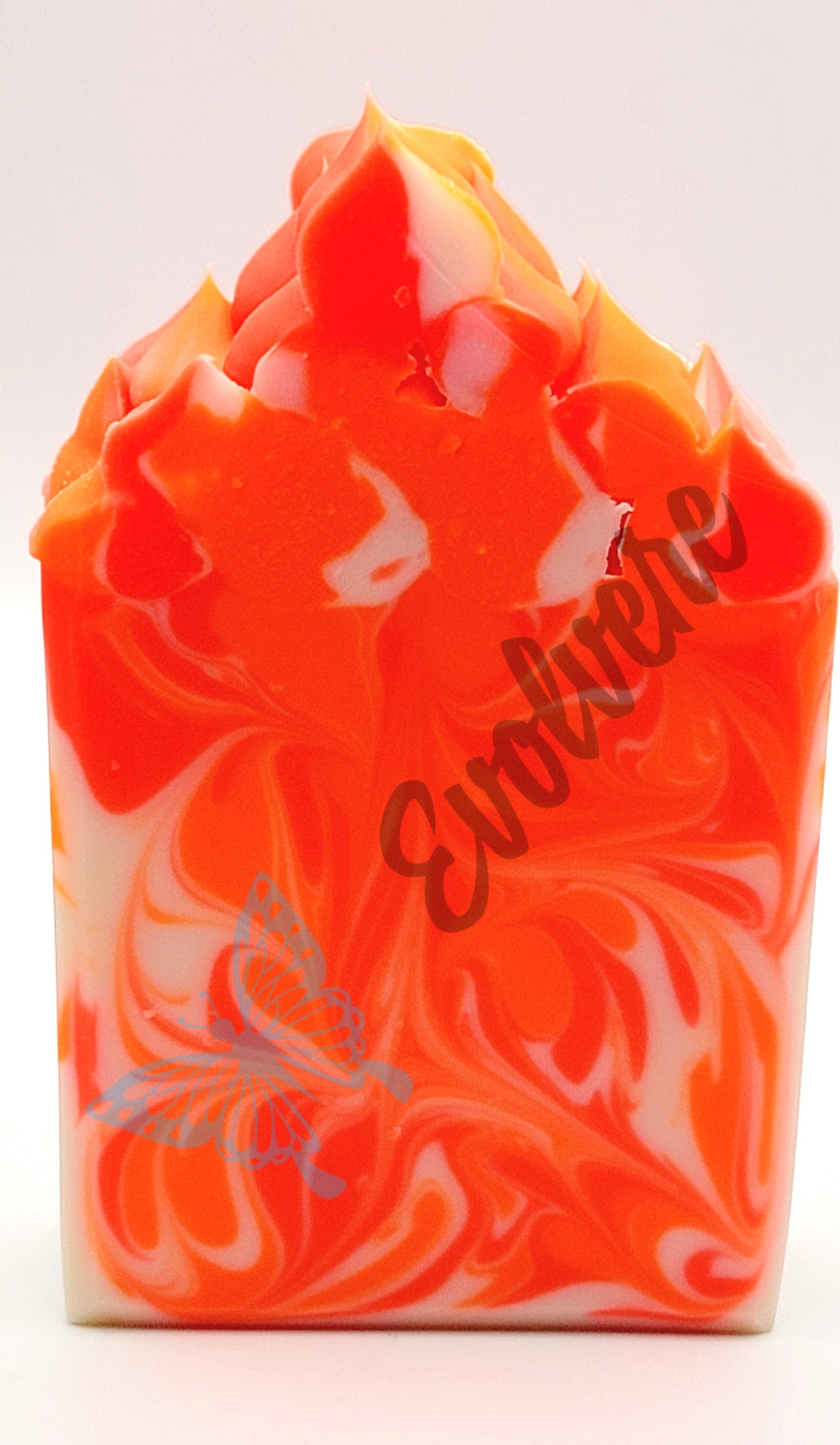 A neon orange and white swirled soap with a piped top. 